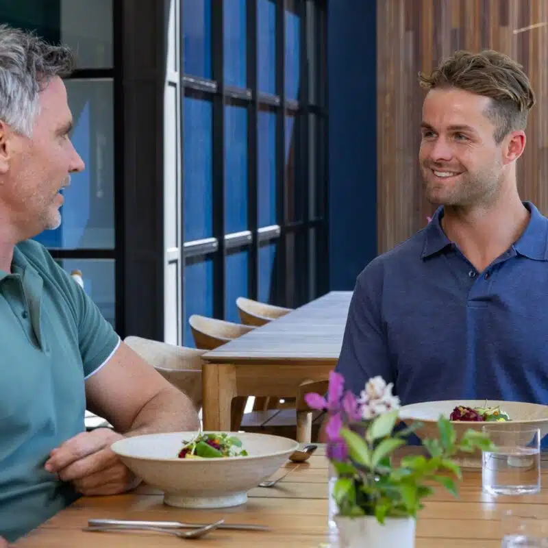 two men eating a meal together having a conversation